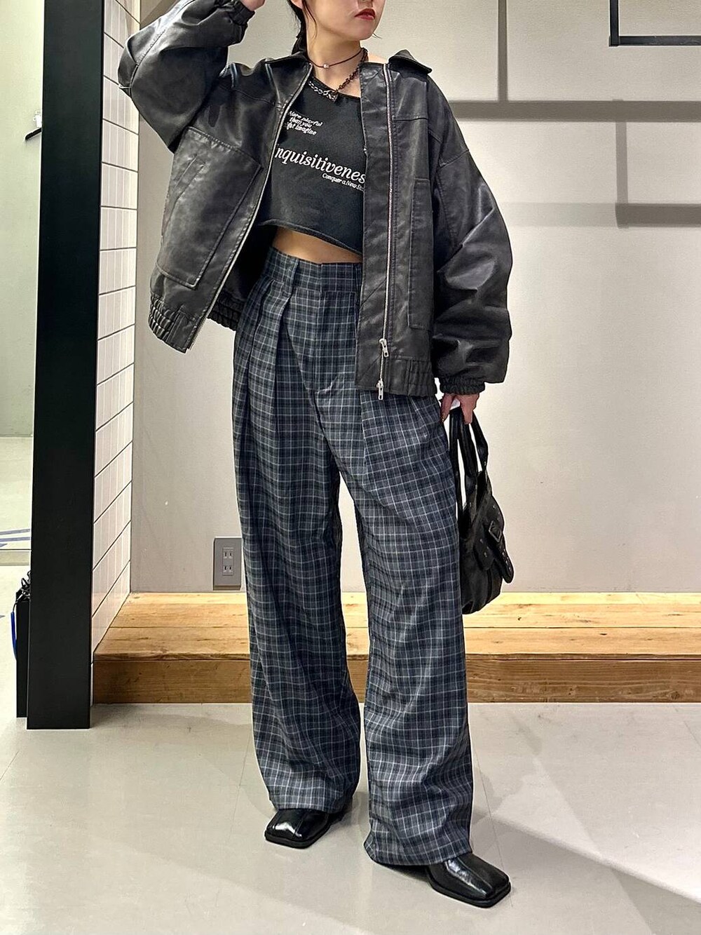 グレー系のブルゾン、ブラック系のブーツ、グレー系のスラックスを着用したレディースの秋コーディネートの7枚目の写真