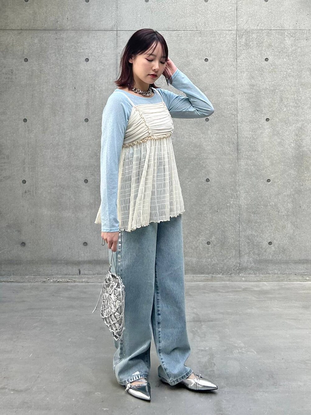 シルバー系のショルダーバッグ、ブルー系のデニムパンツ、ホワイト系のキャミソールを着用したレディースの春コーディネートの4枚目の写真