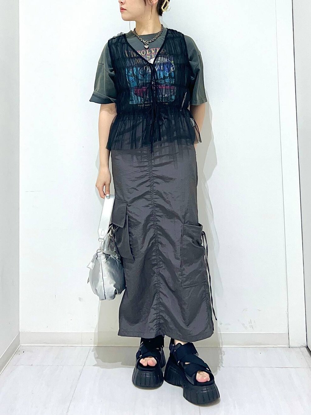 ブラック系のスニーカー、グレー系のTシャツ/カットソー、シルバー系のショルダーバッグを着用したレディースの夏コーディネートの4枚目の写真