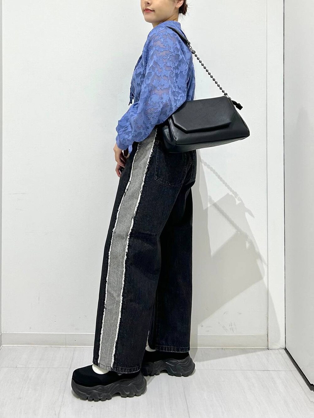 ブラック系のショルダーバッグ、ブラック系のデニムパンツ、ブルー系のシャツ/ブラウスを着用したレディースの春コーディネートの5枚目の写真