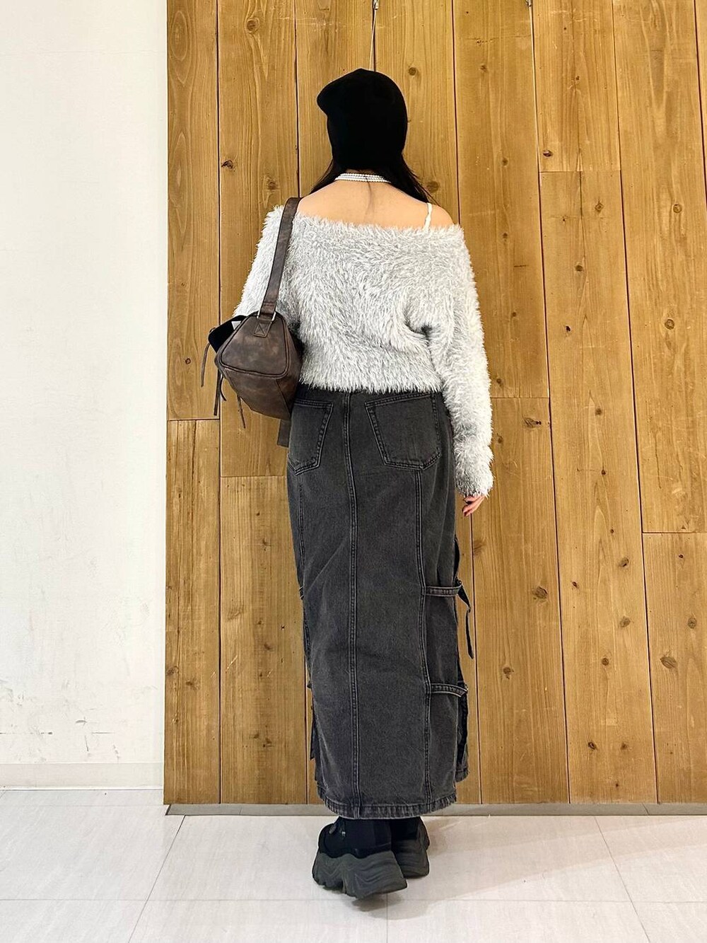 ブラウン系のショルダーバッグ、ブラック系のデニムスカート、ブラック系のスニーカーを着用したレディースの秋コーディネートの5枚目の写真