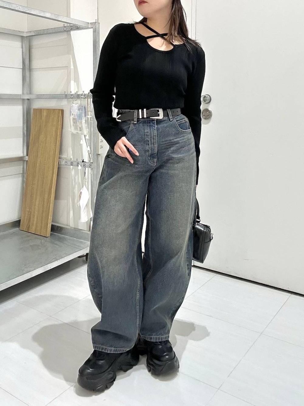 ブラック系のスニーカー、ブラック系のボストンバッグ、ブラック系のニット/セーターを着用したレディースの冬コーディネートの3枚目の写真