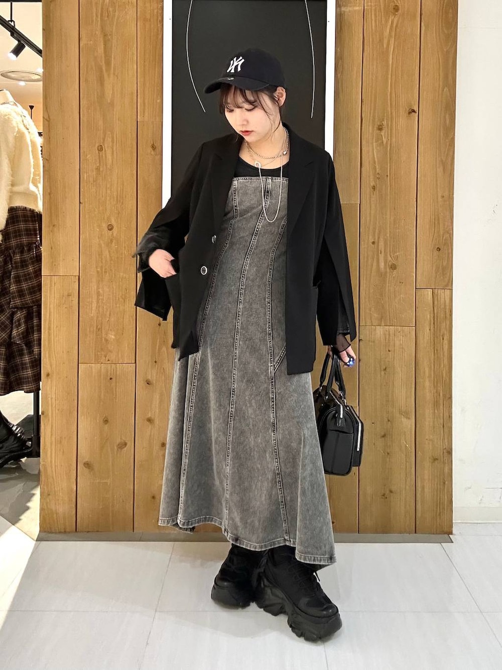 ブラック系のスニーカー、ブラック系のテーラードジャケット、ブラック系のショルダーバッグを着用したレディースの冬コーディネートの2枚目の写真