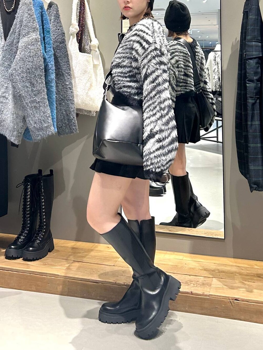 ブラック系のブーツ、ブラック系のショルダーバッグ、その他のカーディガン/ボレロを着用したレディースの秋コーディネートの4枚目の写真