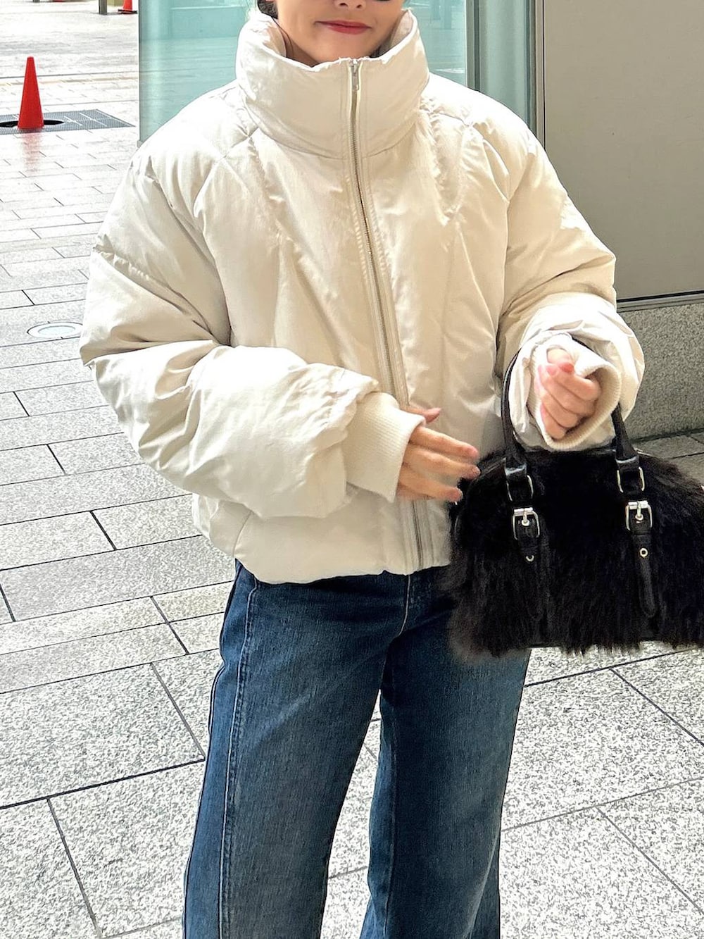 ブルー系のデニムパンツ、ホワイト系のブルゾン、ブラック系のブーツを着用したレディースの冬コーディネートの3枚目の写真