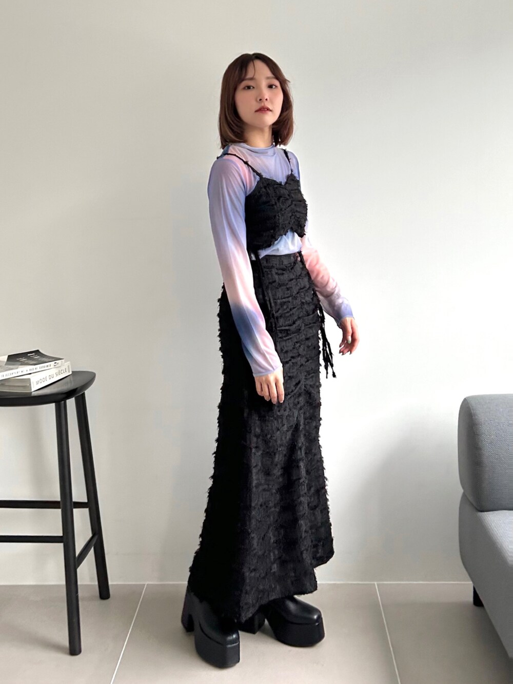 ブラック系のワンピース、ピンク系のTシャツ/カットソー、ブラック系のブーツを着用したレディースの秋コーディネートの4枚目の写真