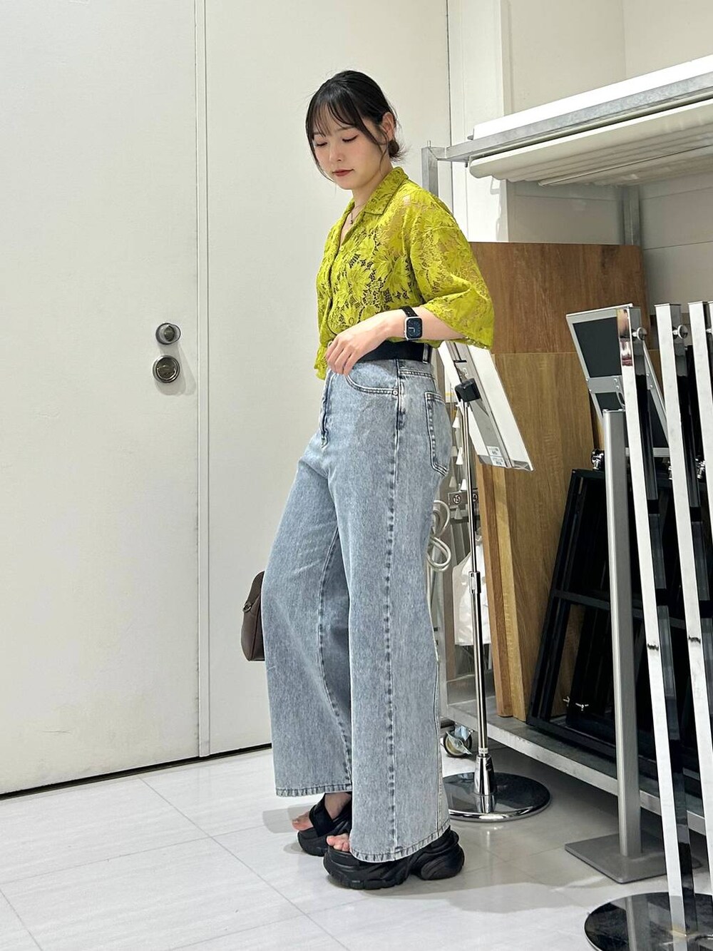 ブラック系のサンダル、ブラック系のキャミソール、ブルー系のデニムパンツを着用したレディースの夏コーディネートの5枚目の写真