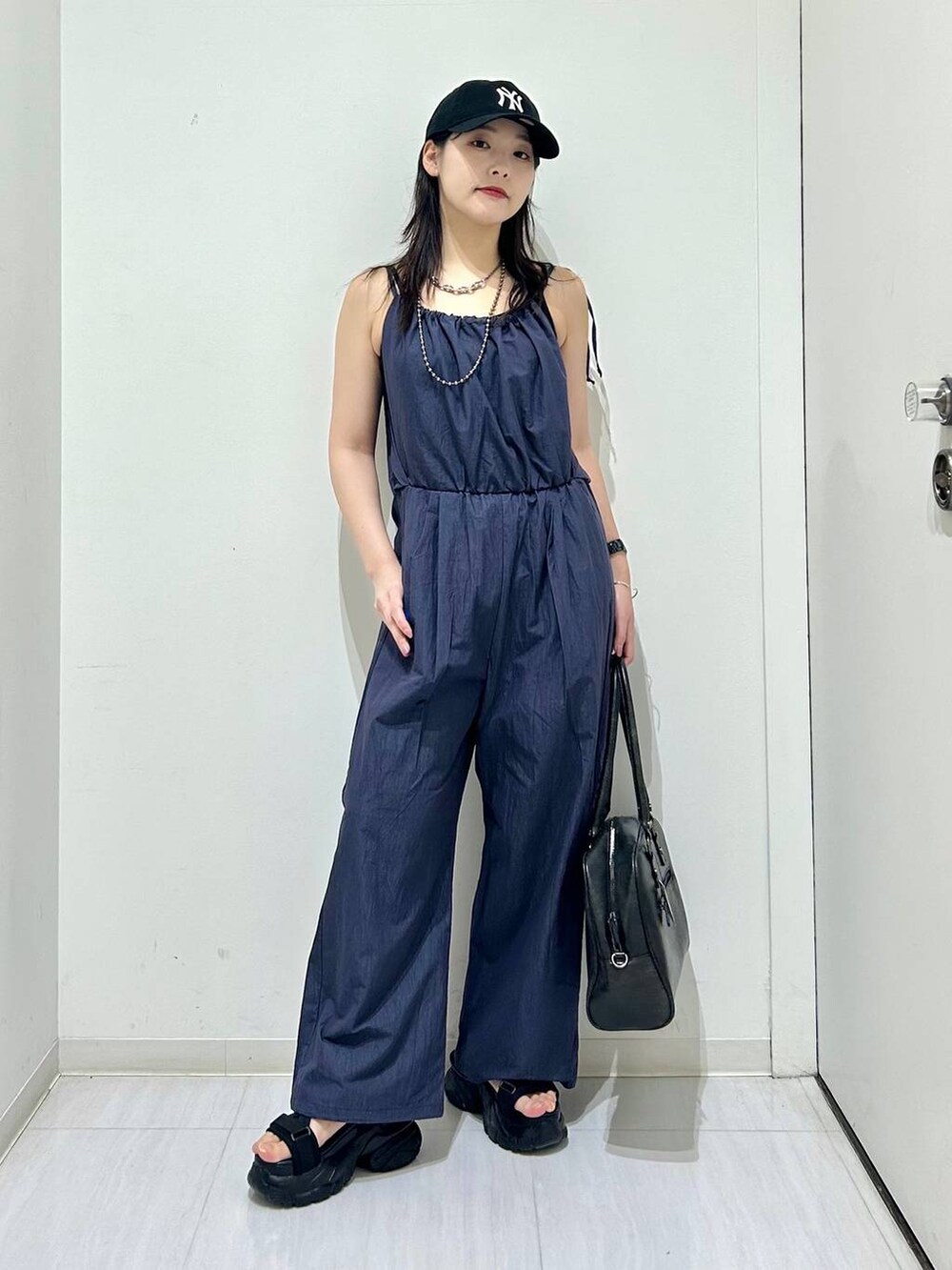 ブラック系のボストンバッグ、ブラック系のサンダル、ブラック系のキャミソールを着用したレディースの春コーディネートの2枚目の写真