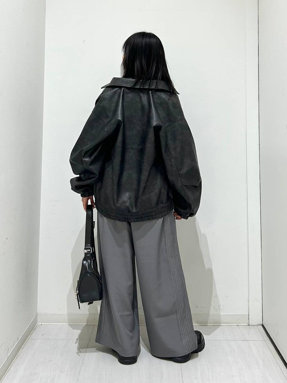 ブラック系のブルゾン、ブラック系のスニーカー、ブラック系のショルダーバッグを着用したレディースの春コーディネートの7枚目の写真