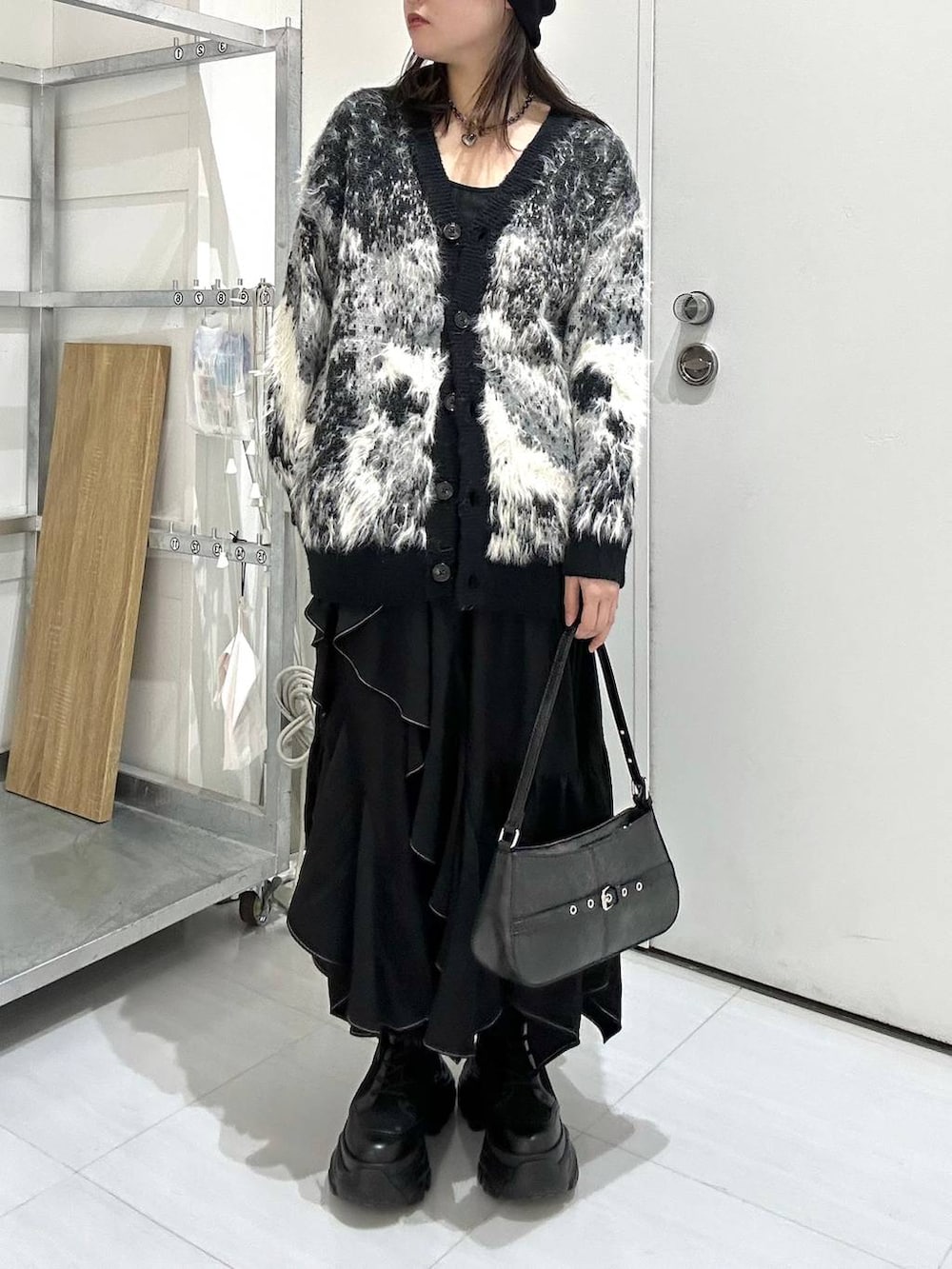 ブラック系のブーツ、ブラック系のカーディガン/ボレロ、ブラック系のスカートを着用したレディースの冬コーディネートの3枚目の写真