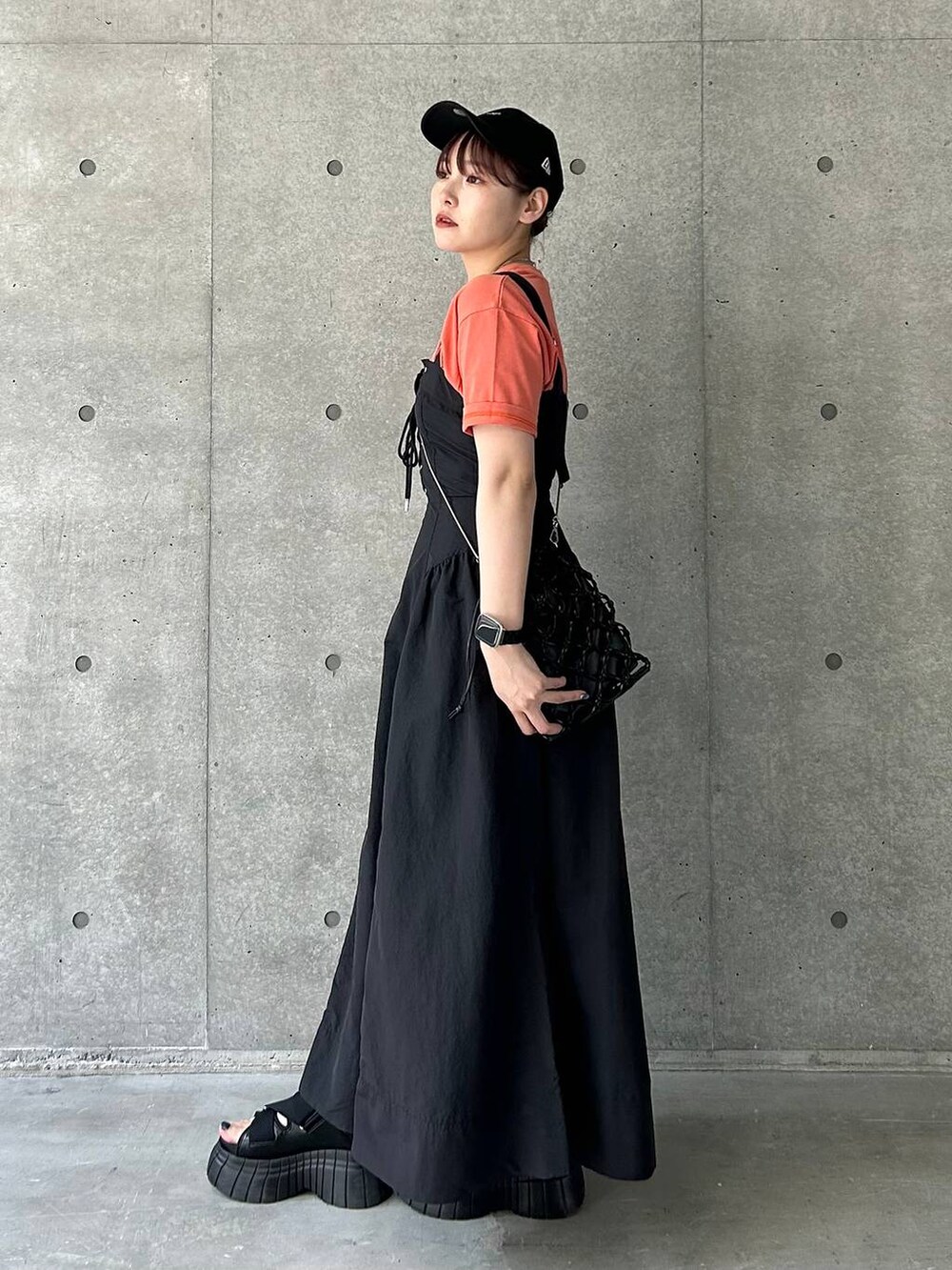 ブラック系のスニーカー、ブラック系のショルダーバッグ、ブラック系のワンピースを着用したレディースの夏コーディネートの6枚目の写真