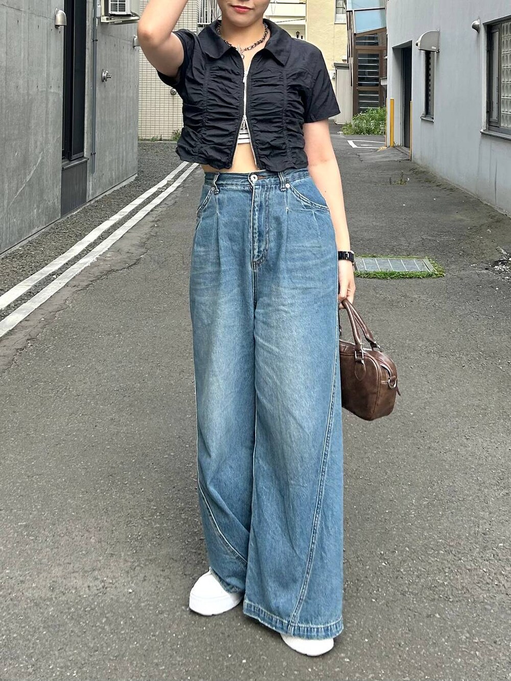 ブルー系のデニムパンツ、ブラック系のキャミソール、ブラック系のシャツ/ブラウスを着用したレディースの夏コーディネートの3枚目の写真