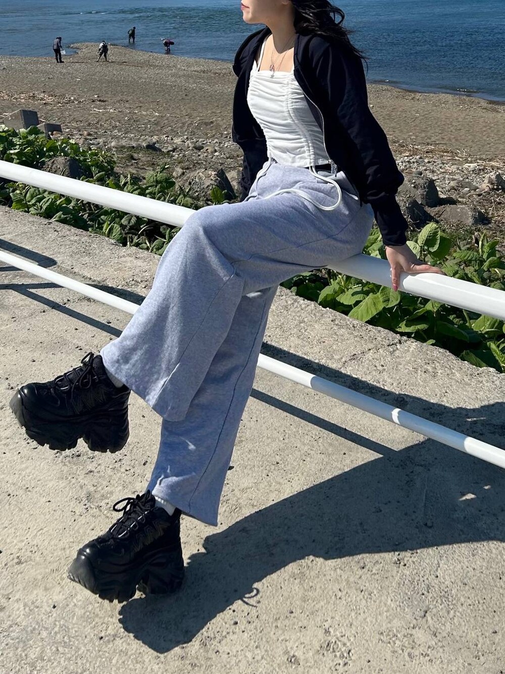 ブラック系のスニーカー、ブルー系のパーカー、グレー系のスウェットパンツを着用したレディースの春コーディネートの2枚目の写真