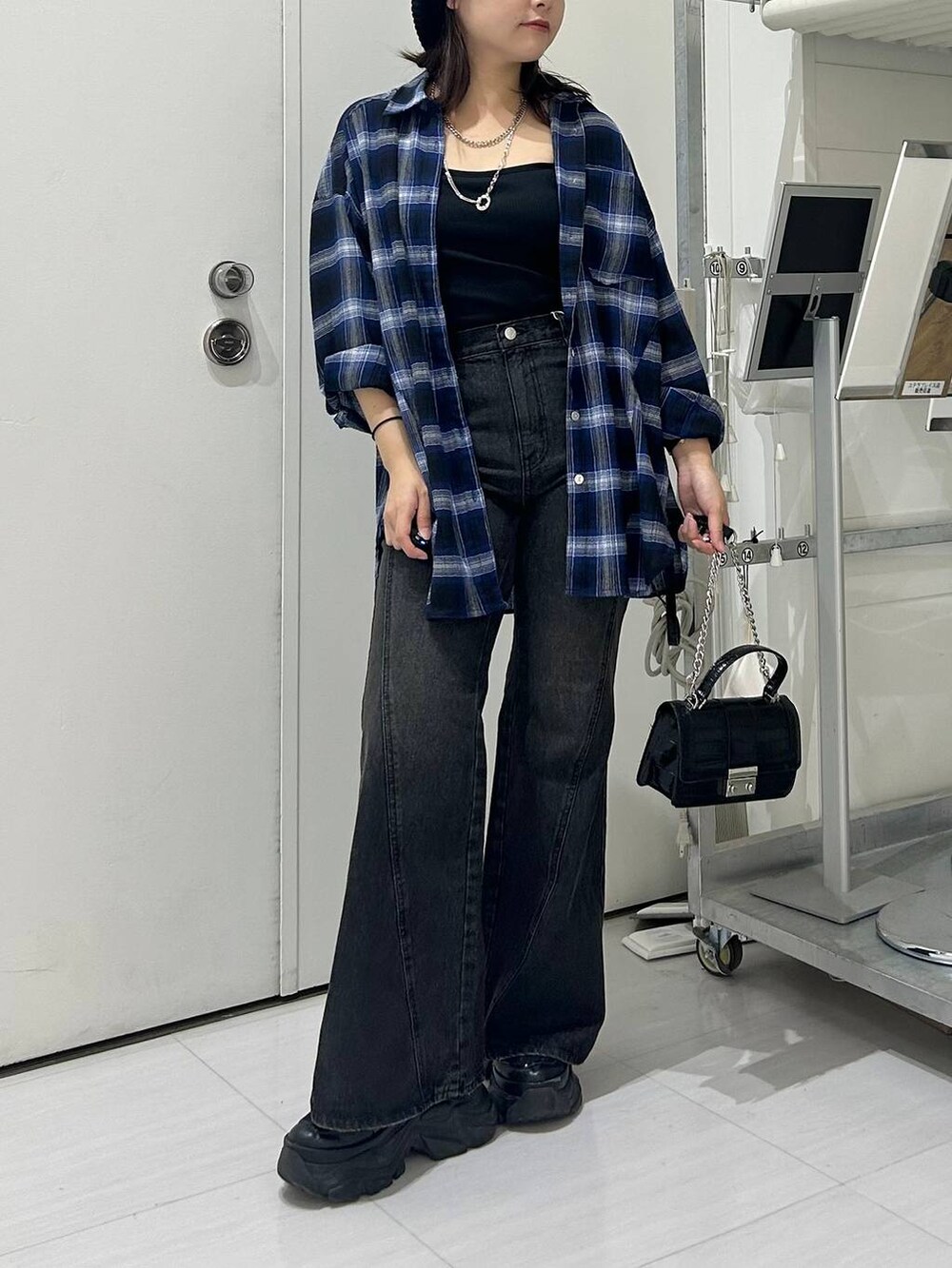 ブラック系のスニーカー、ブルー系のデニムパンツ、ブルー系のシャツ/ブラウスを着用したレディースの秋コーディネートの2枚目の写真