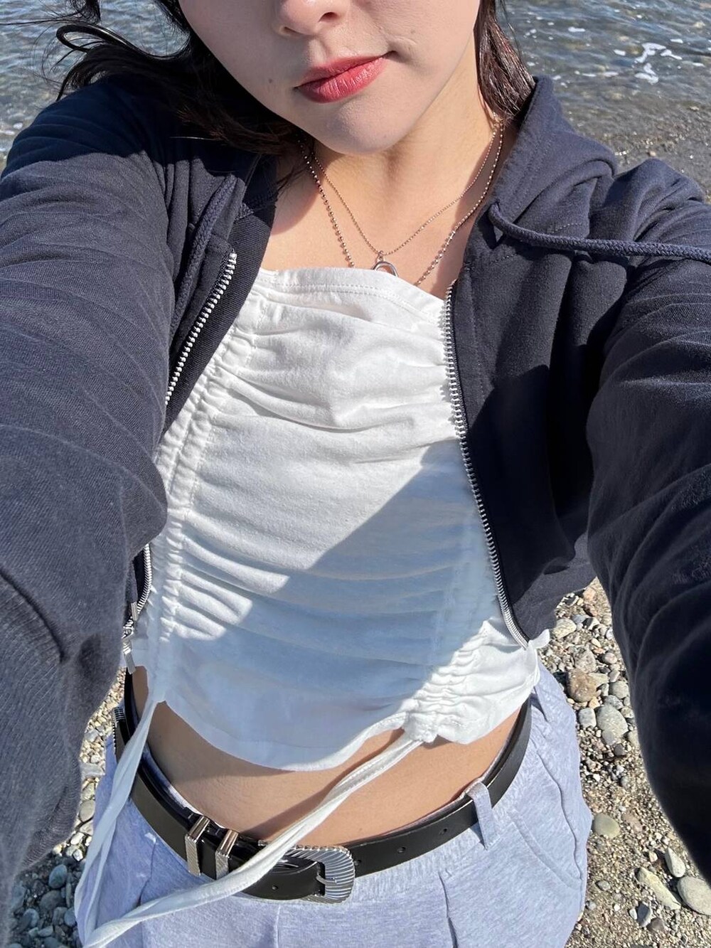 ブラック系のスニーカー、ブルー系のパーカー、グレー系のスウェットパンツを着用したレディースの春コーディネートの3枚目の写真