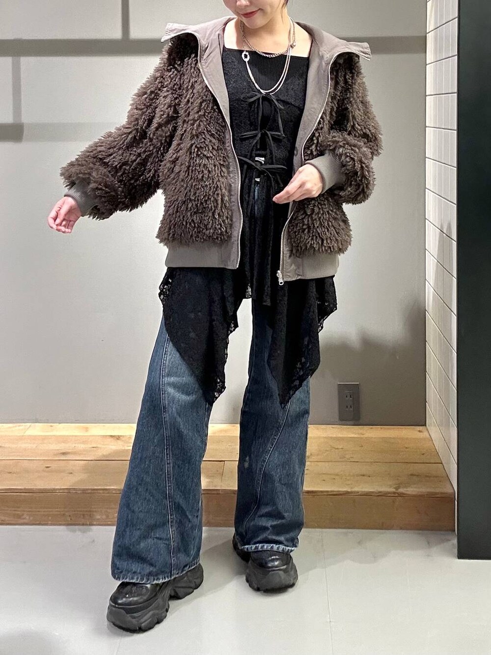 ブラック系のスニーカー、ブルー系のデニムパンツ、ブラック系のブルゾンを着用したレディースの秋コーディネートの2枚目の写真