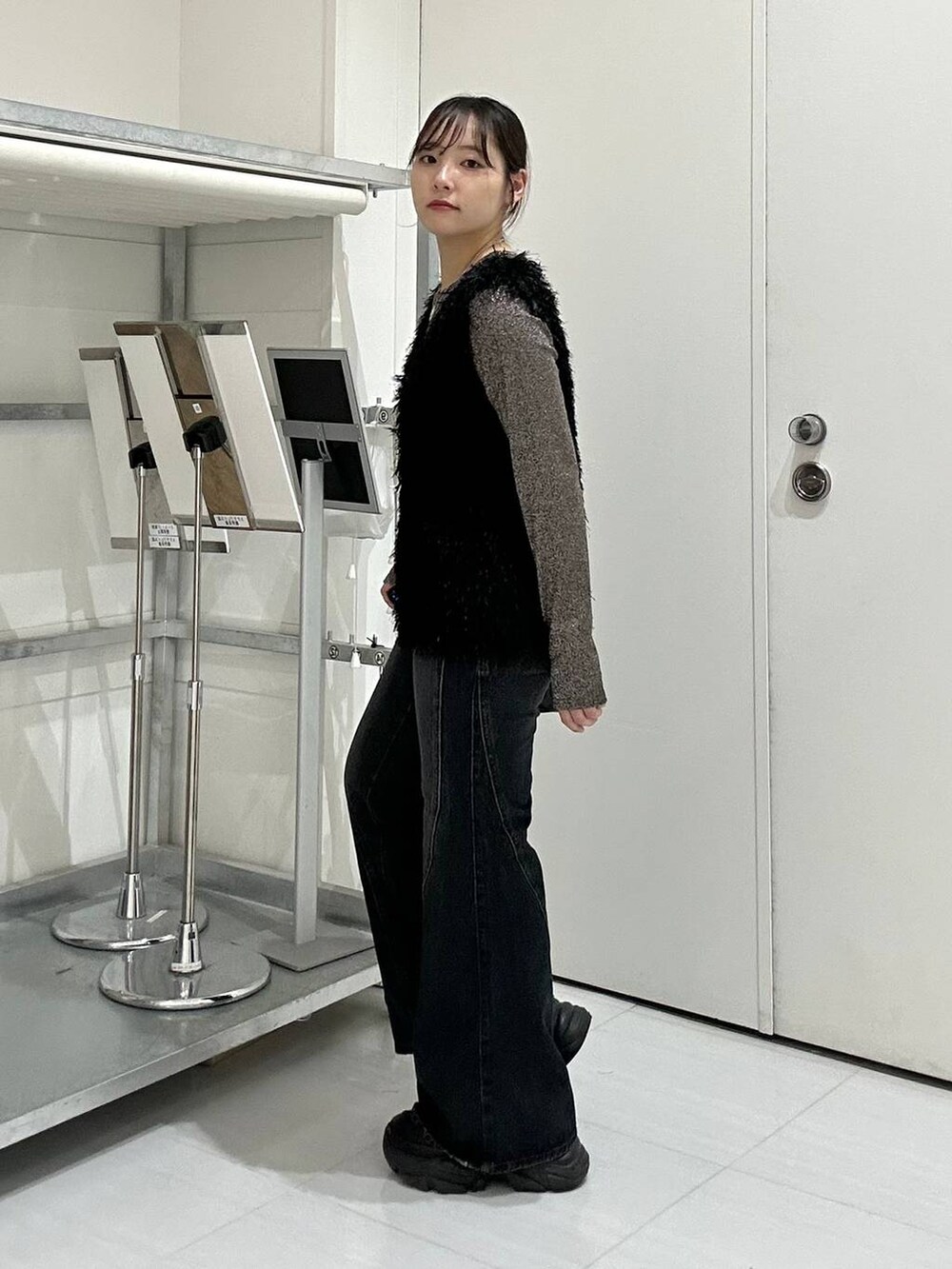 ブラウン系のTシャツ/カットソー、ブルー系のデニムパンツ、ブラック系のベストを着用したレディースの秋コーディネートの6枚目の写真