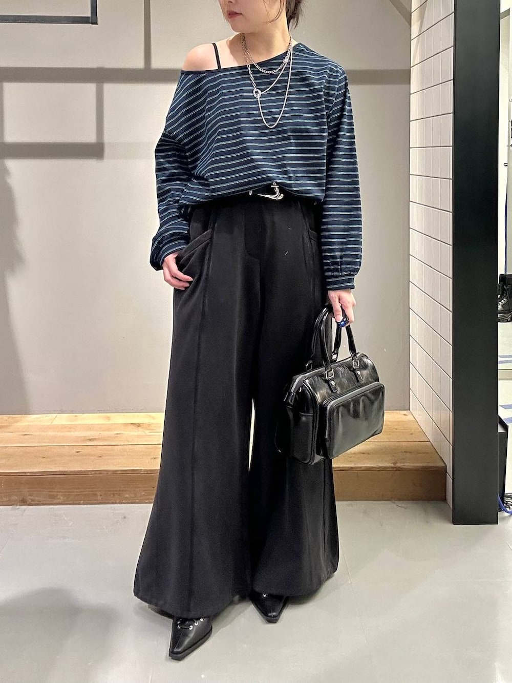 ブラック系のスウェットパンツ、ブラック系のショルダーバッグ、ブラック系のサンダルを着用したレディースの冬コーディネートの3枚目の写真