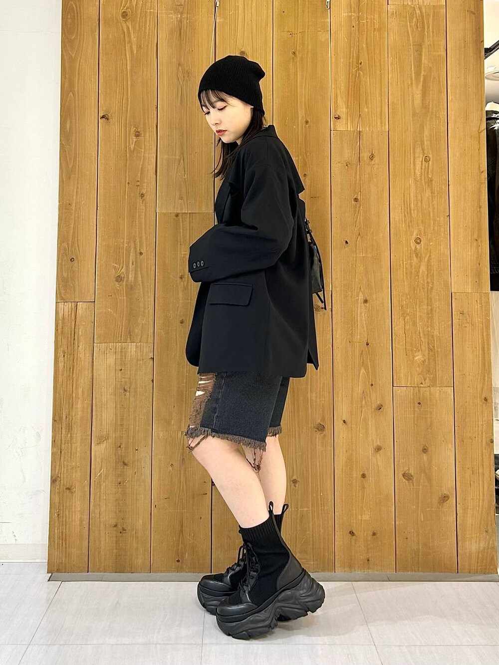 ブラック系のテーラードジャケット、ブラック系のショルダーバッグ、ブラック系のブーツを着用したレディースの秋コーディネートの5枚目の写真