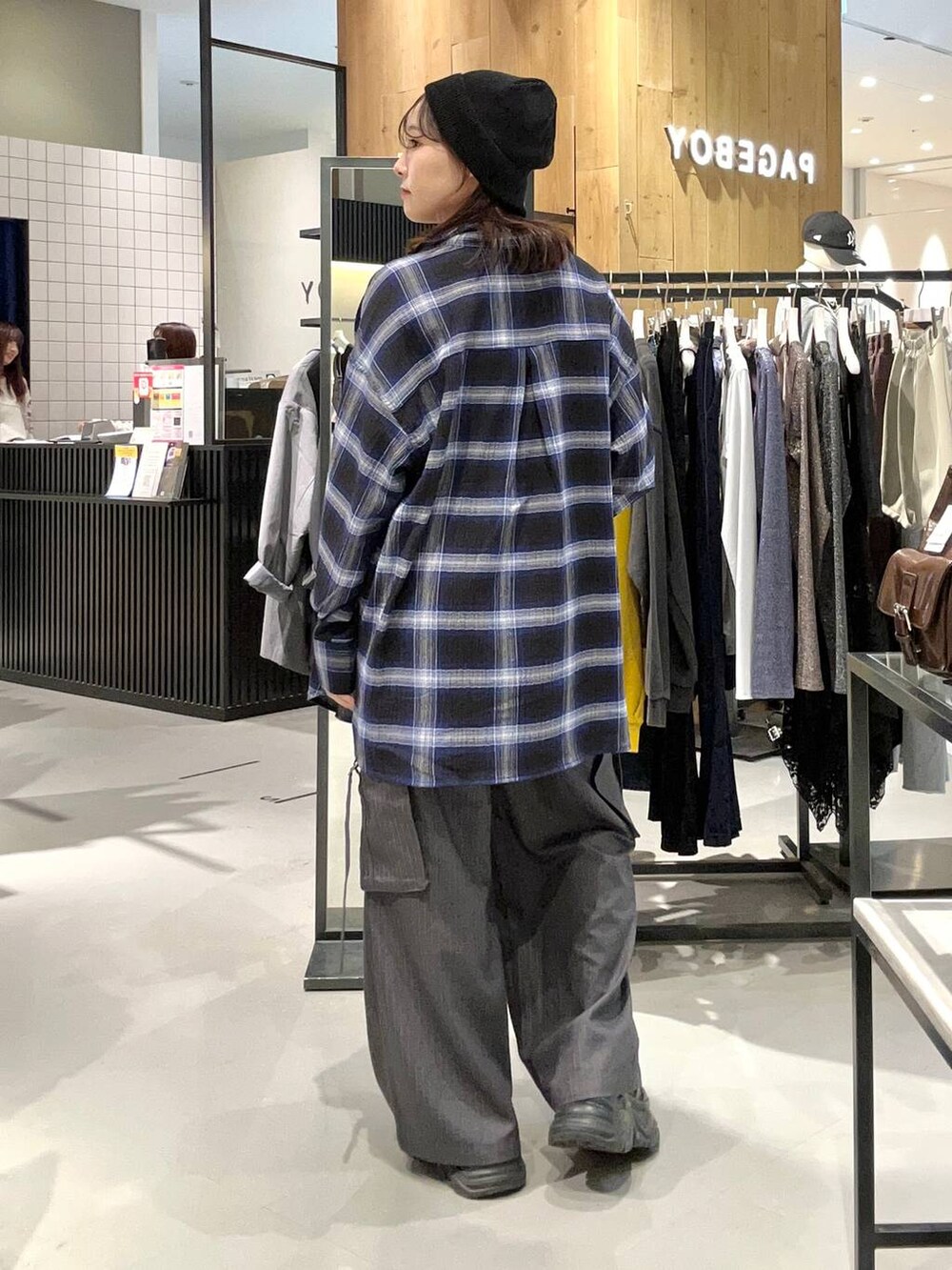 ブラック系のスニーカー、ブルー系のシャツ/ブラウス、グレー系のスラックスを着用したレディースの秋コーディネートの6枚目の写真