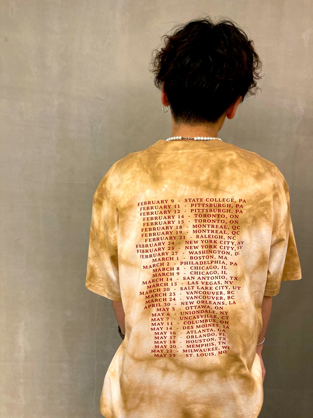 ブルー系のデニムパンツ、ホワイト系のスニーカー、グリーン系のTシャツ/カットソーを着用したメンズの夏コーディネートの4枚目の写真