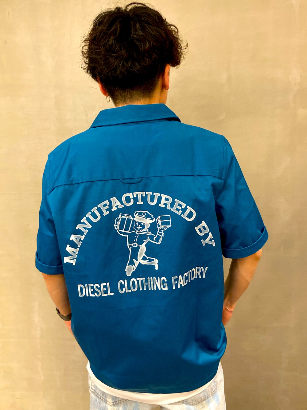 ブルー系のデニムパンツ、ホワイト系のスニーカー、ブルー系のシャツ/ブラウスを着用したメンズの春コーディネートの2枚目の写真