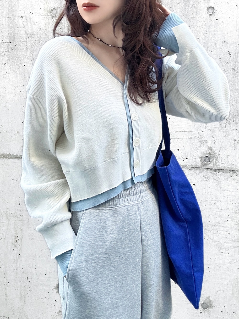 ホワイト系のカーディガン/ボレロ、ブルー系のトートバッグ、ベージュ系のスニーカーを着用したレディースの春コーディネートの3枚目の写真