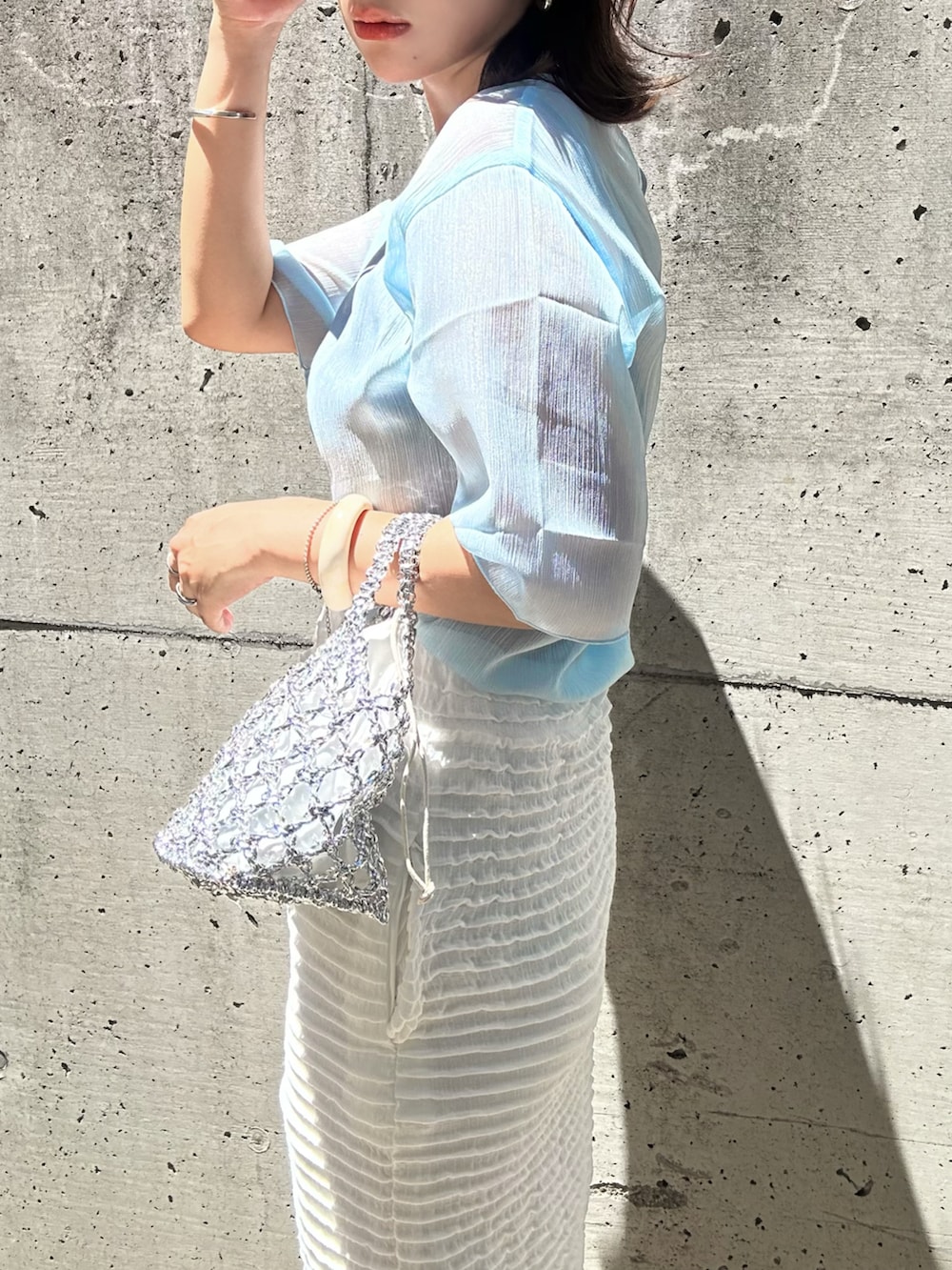 ブルー系のシャツ/ブラウス、ホワイト系のスカート、ホワイト系のかごバッグを着用したレディースの夏コーディネートの2枚目の写真