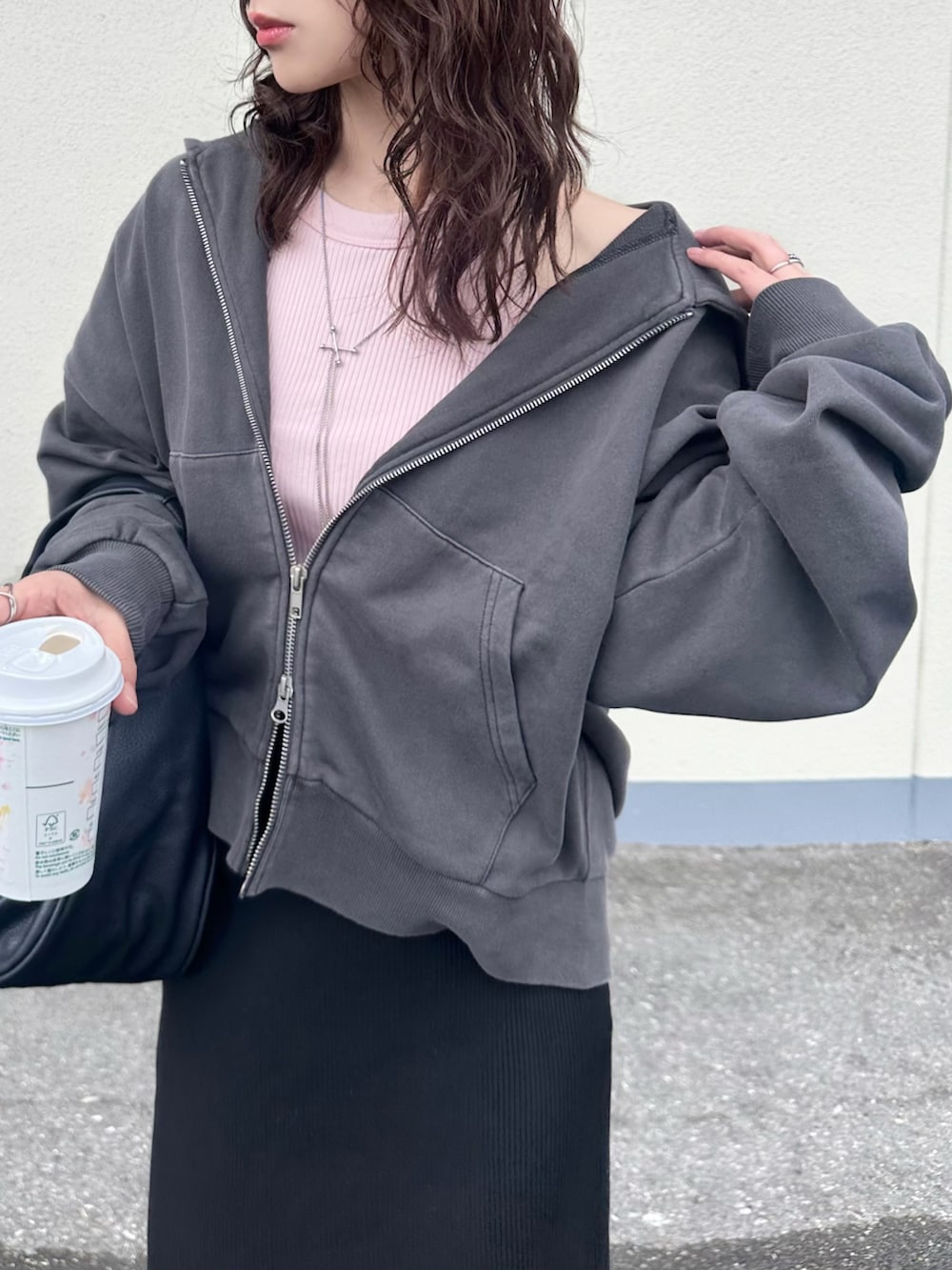 グレー系のパーカー、ピンク系のタンクトップ、ブラック系のスカートを着用したレディースの春コーディネートの3枚目の写真