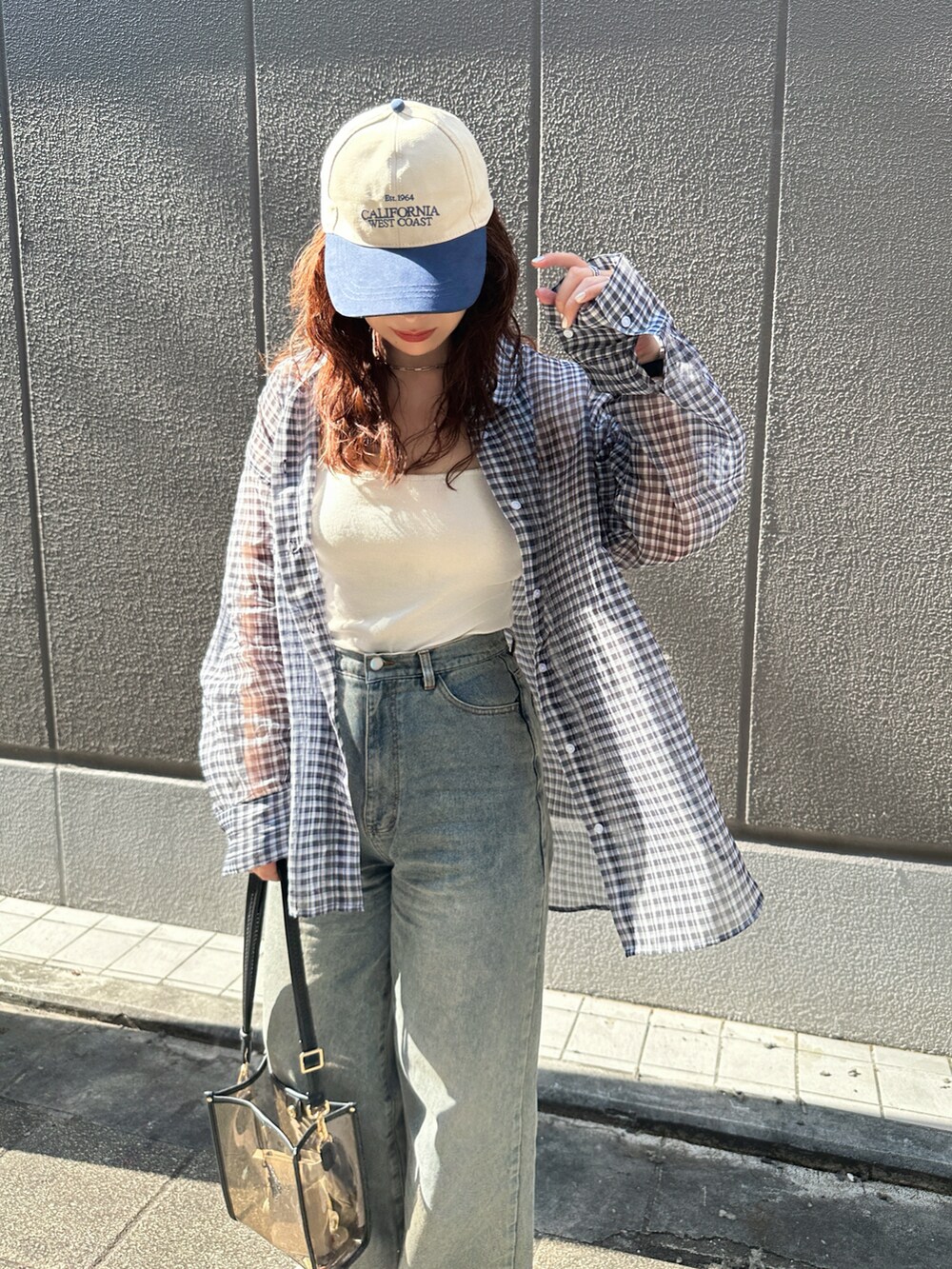 ブラック系のシャツ/ブラウス、ホワイト系のキャミソール、ブルー系のデニムパンツを着用したレディースの夏コーディネートの3枚目の写真