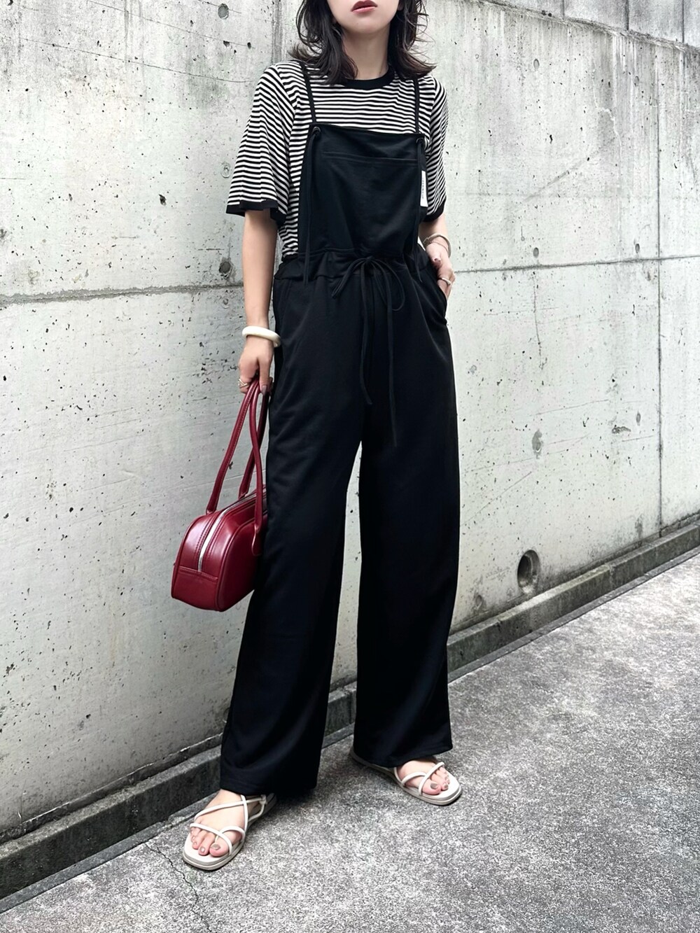 ベージュ系のニット/セーター、ホワイト系のサンダルを着用したレディースの夏コーディネートの2枚目の写真