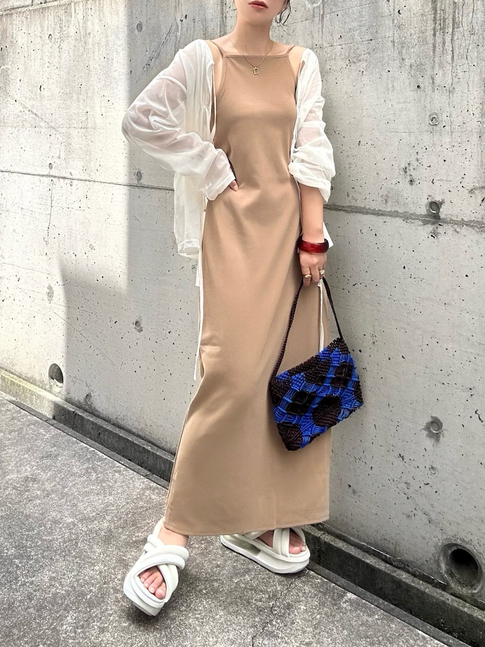 ベージュ系のワンピース、ホワイト系のシャツ/ブラウス、ブラウン系のバッグを着用したレディースの夏コーディネートの3枚目の写真