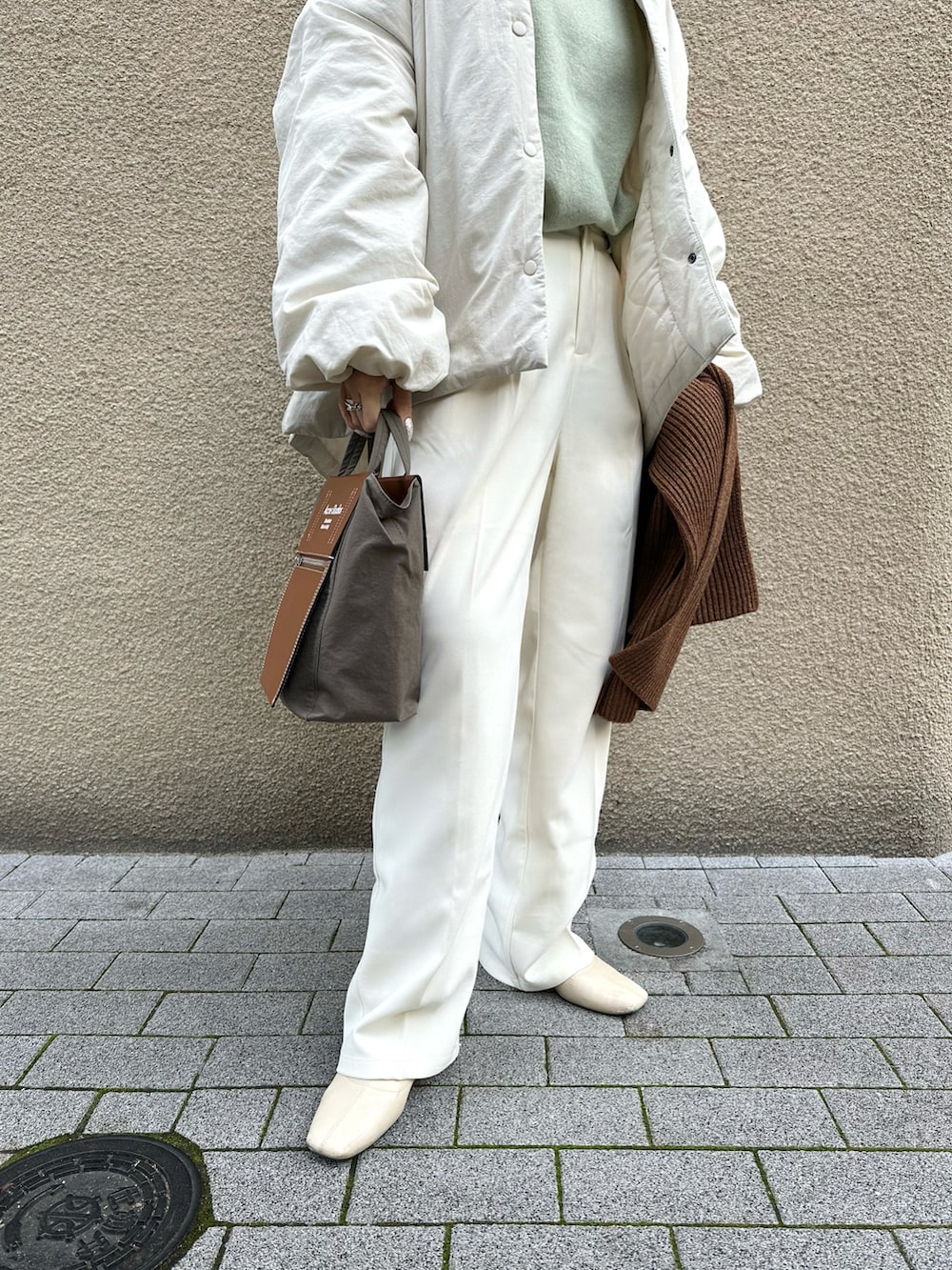 ホワイト系のその他パンツ、グリーン系のニット/セーター、ホワイト系のダウンジャケット/コートを着用したレディースの冬コーディネートの3枚目の写真