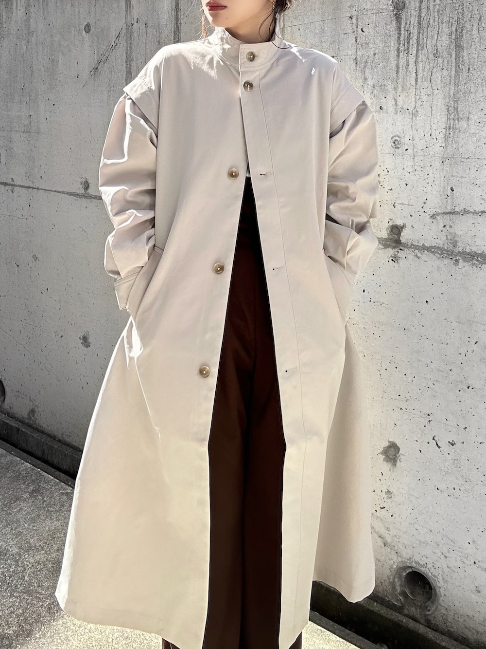 ベージュ系のトレンチコート、グレー系のシャツ/ブラウス、ブラウン系のサロペット/オーバーオールを着用したレディースの春コーディネートの4枚目の写真