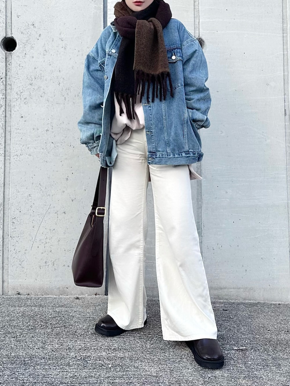 ホワイト系のデニムパンツ、ベージュ系のスウェット、ブルー系のデニムジャケットを着用したレディースの冬コーディネートの2枚目の写真
