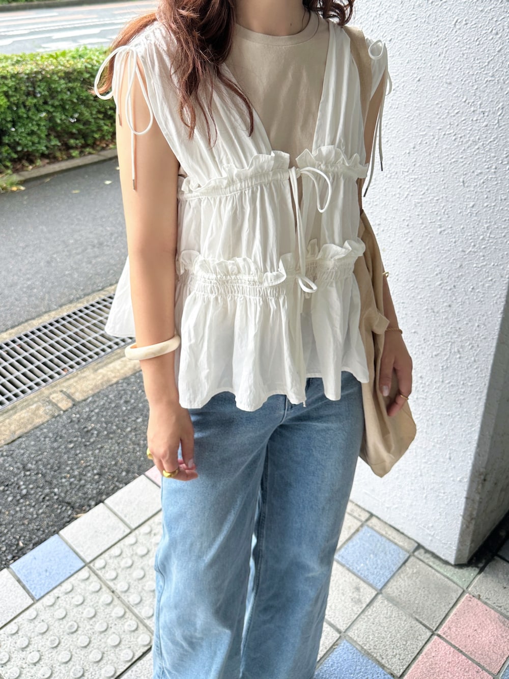 ホワイト系のシャツ/ブラウス、ブルー系のデニムパンツ、ベージュ系のサンダルを着用したレディースの夏コーディネートの3枚目の写真