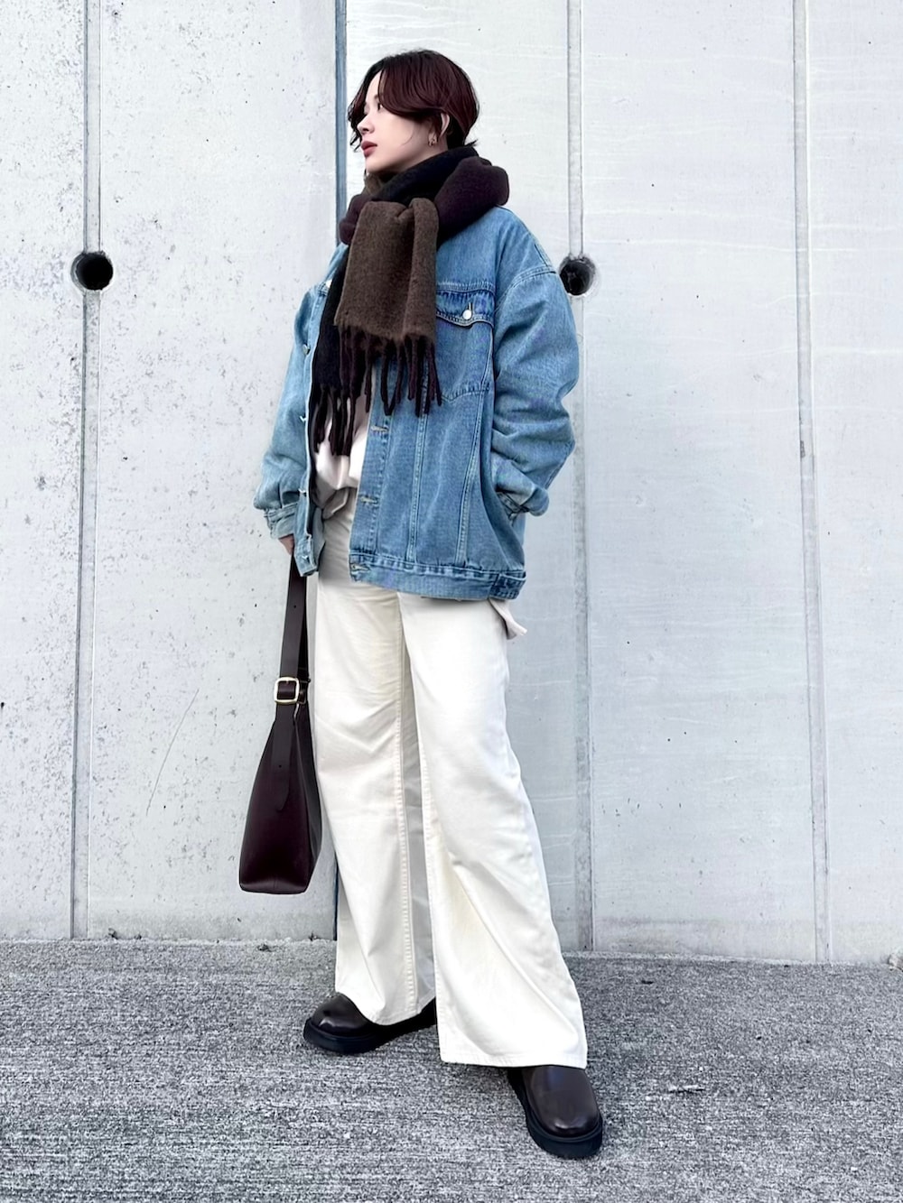ホワイト系のデニムパンツ、ベージュ系のスウェット、ブルー系のデニムジャケットを着用したレディースの冬コーディネートの3枚目の写真