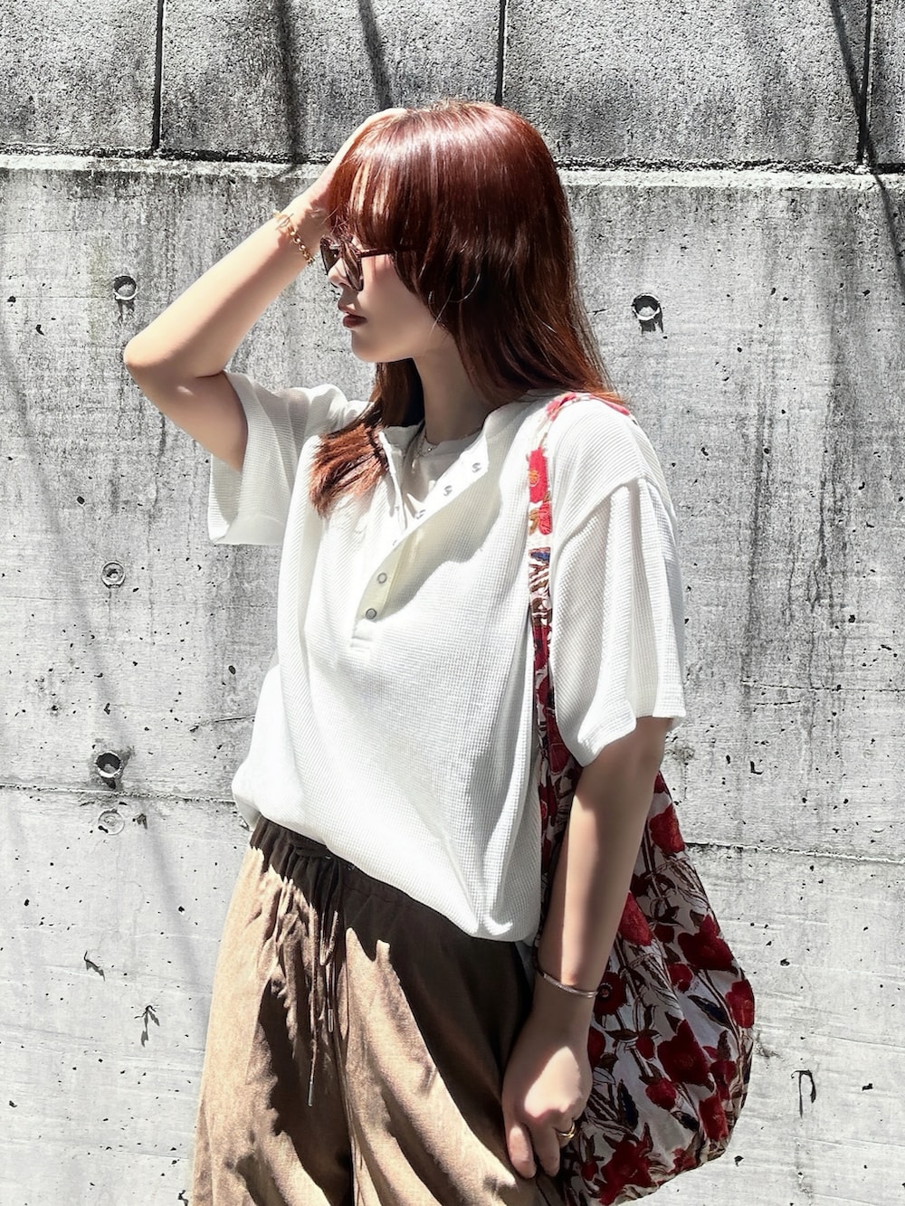 ホワイト系のTシャツ/カットソー、ブラウン系のスラックス、ゴールド系のサンダルを着用したレディースの夏コーディネートの5枚目の写真