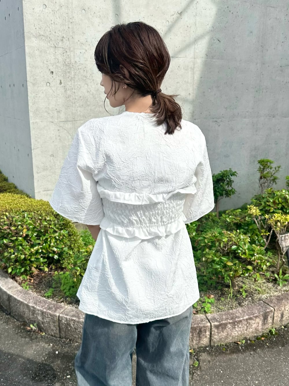 ホワイト系のTシャツ/カットソー、ブルー系のデニムパンツ、シルバー系のバッグを着用したレディースの夏コーディネートの4枚目の写真