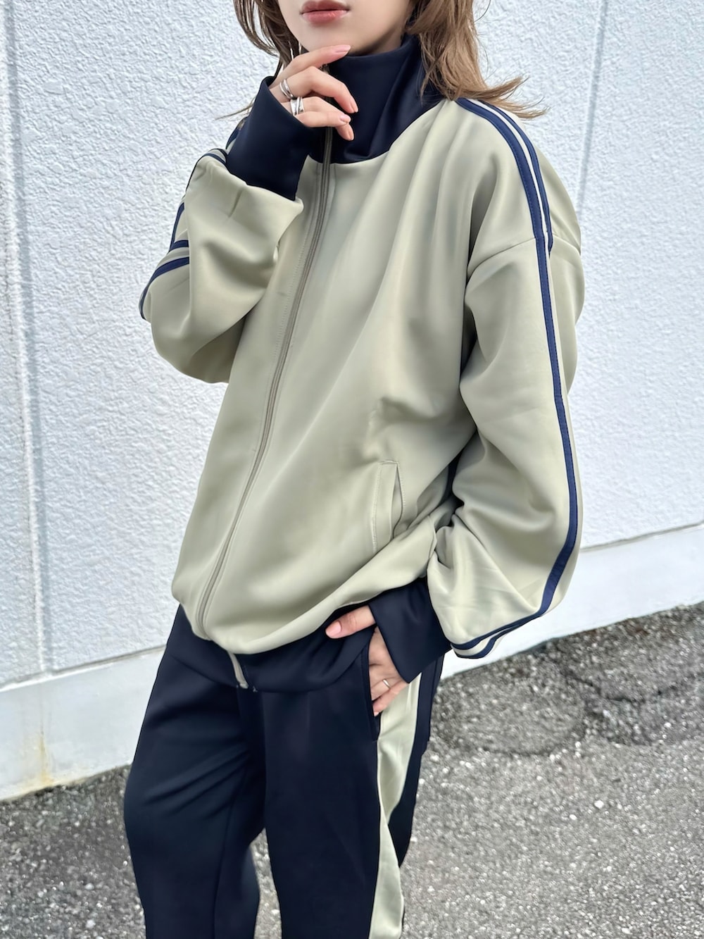ベージュ系のジャージ、ブルー系のスウェットパンツ、ブラック系のその他シューズを着用したレディースの秋コーディネートの2枚目の写真