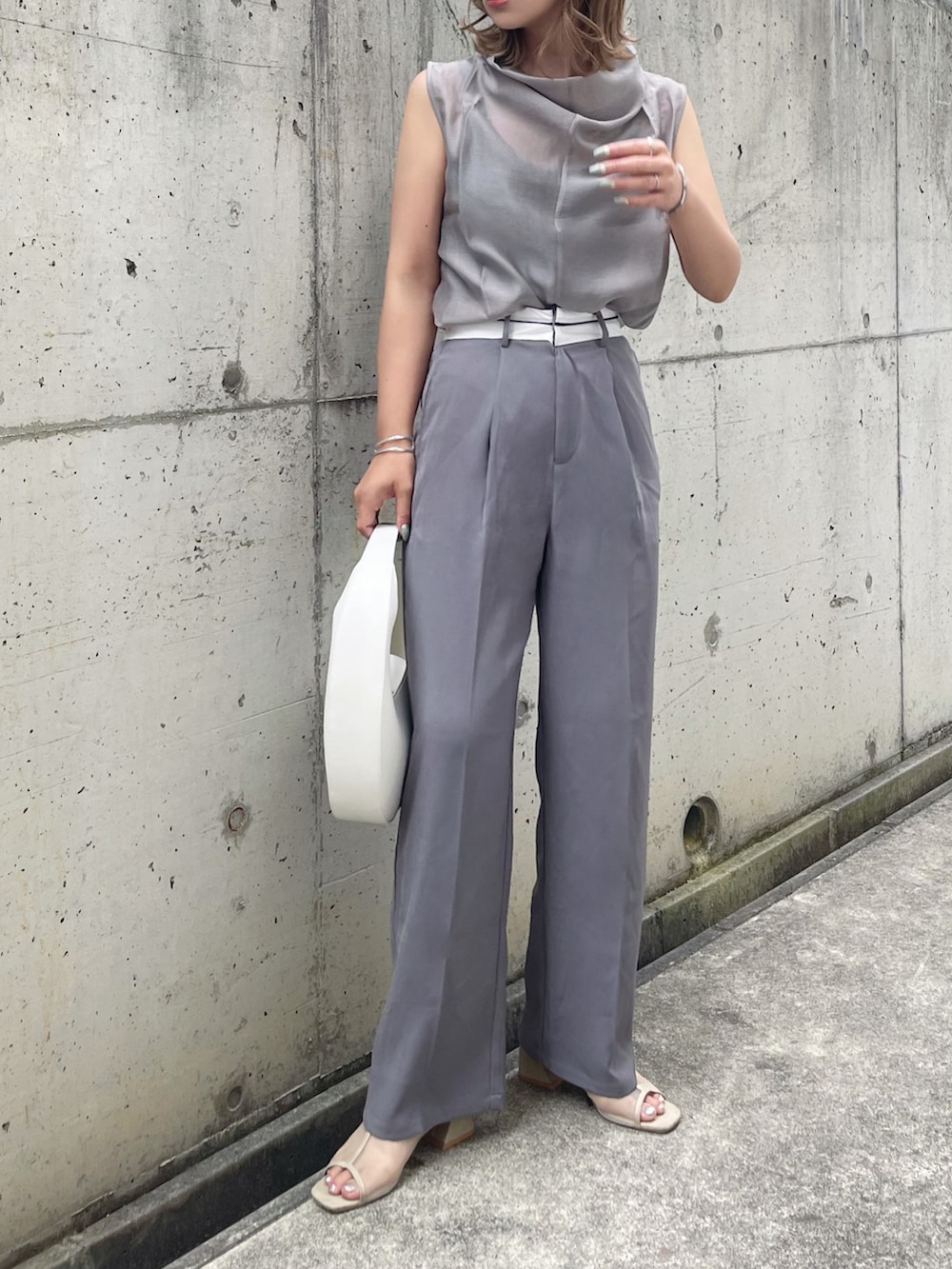 グレー系のTシャツ/カットソー、グレー系のその他パンツ、ベージュ系のサンダルを着用したレディースの春コーディネートの2枚目の写真