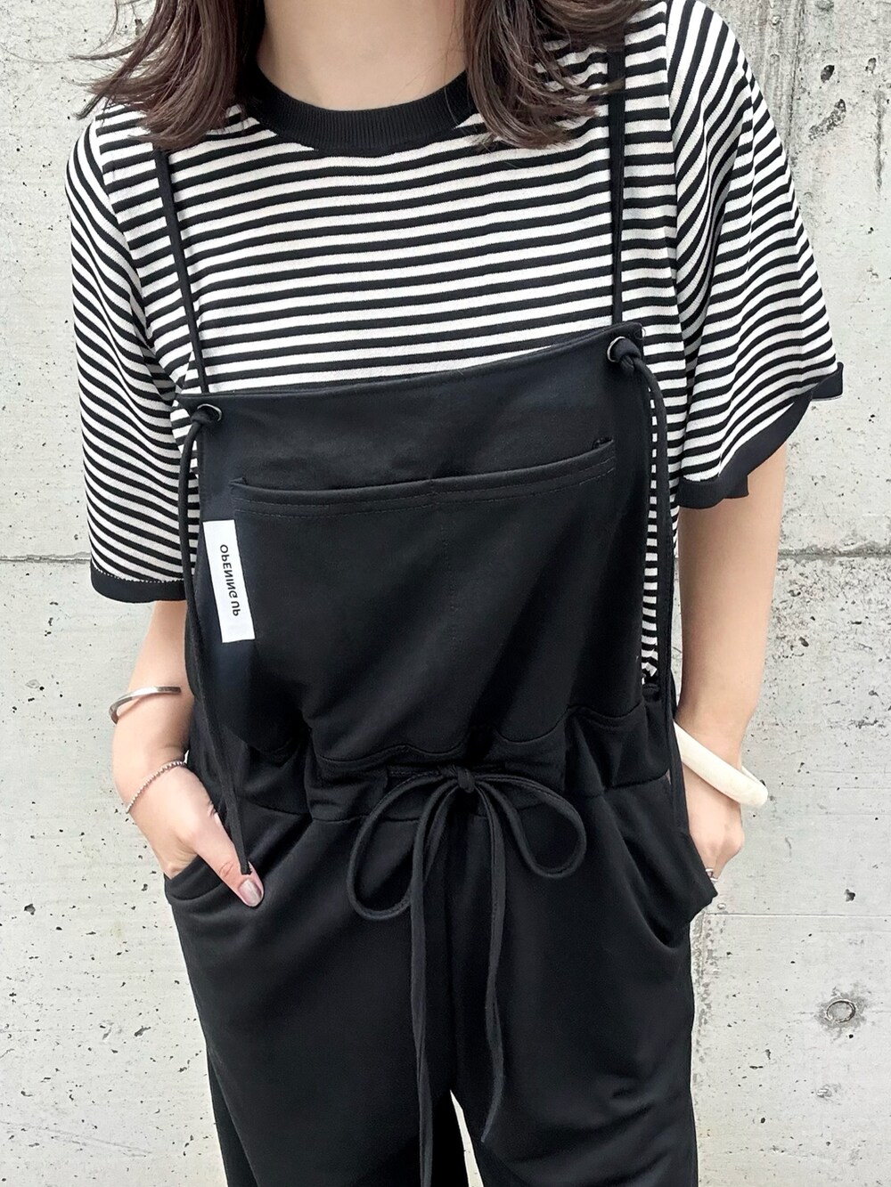 ベージュ系のニット/セーター、ホワイト系のサンダルを着用したレディースの夏コーディネートの3枚目の写真