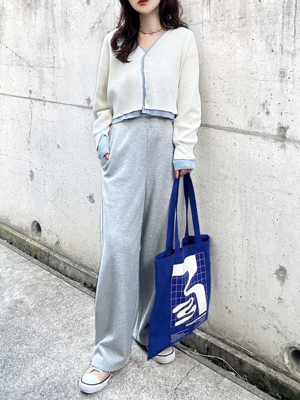ホワイト系のカーディガン/ボレロ、ブルー系のトートバッグ、ベージュ系のスニーカーを着用したレディースの春コーディネートの2枚目の写真