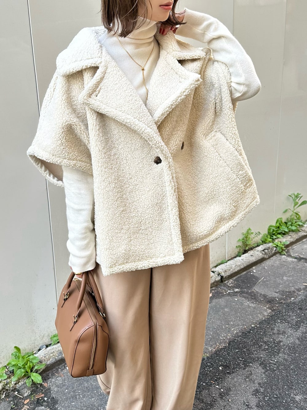 ホワイト系のステンカラーコート、ベージュ系のその他パンツ、ホワイト系のニット/セーターを着用したレディースの冬コーディネートの4枚目の写真