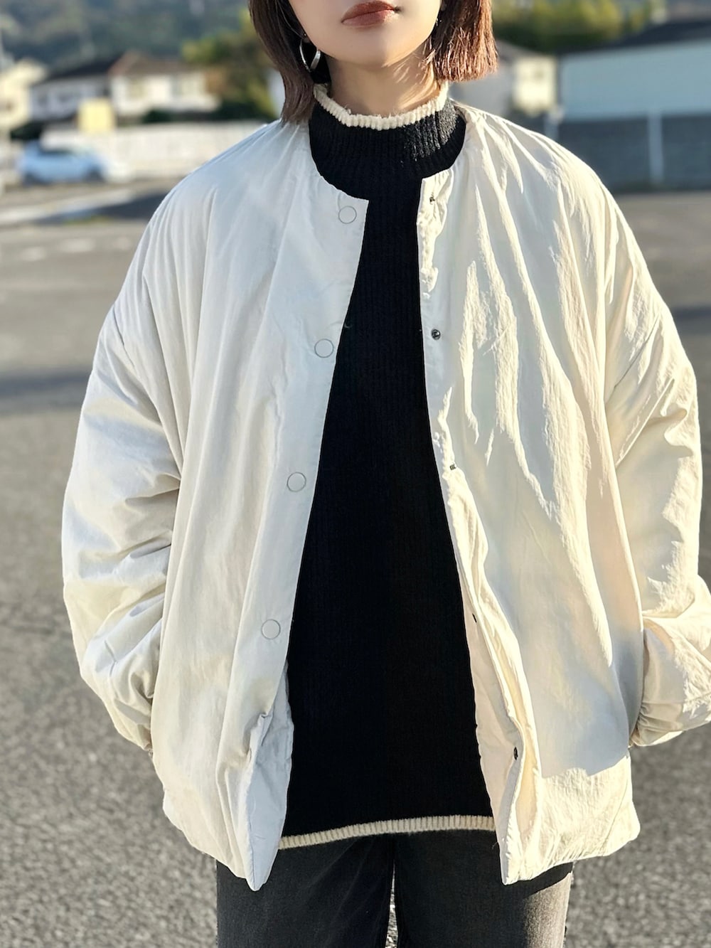 ホワイト系のダウンジャケット/コート、ブラック系のニット/セーター、ブラック系のデニムパンツを着用したレディースの秋コーディネートの4枚目の写真