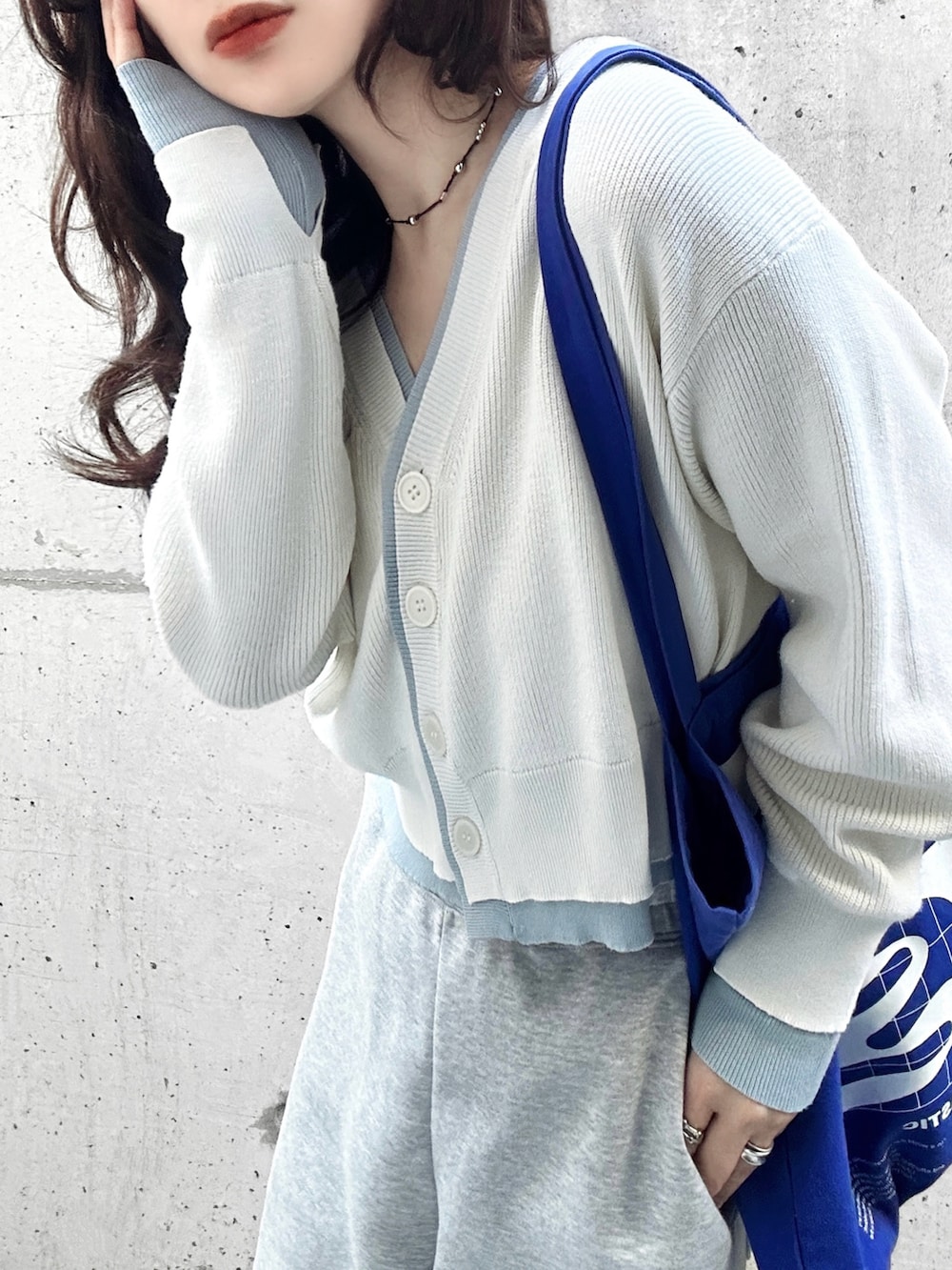 ホワイト系のカーディガン/ボレロ、ブルー系のトートバッグ、ベージュ系のスニーカーを着用したレディースの春コーディネートの4枚目の写真
