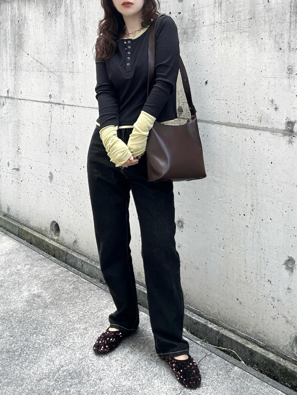 ブラック系のTシャツ/カットソー、ブラック系のデニムパンツ、ブラウン系のトートバッグを着用したレディースの春コーディネートの2枚目の写真