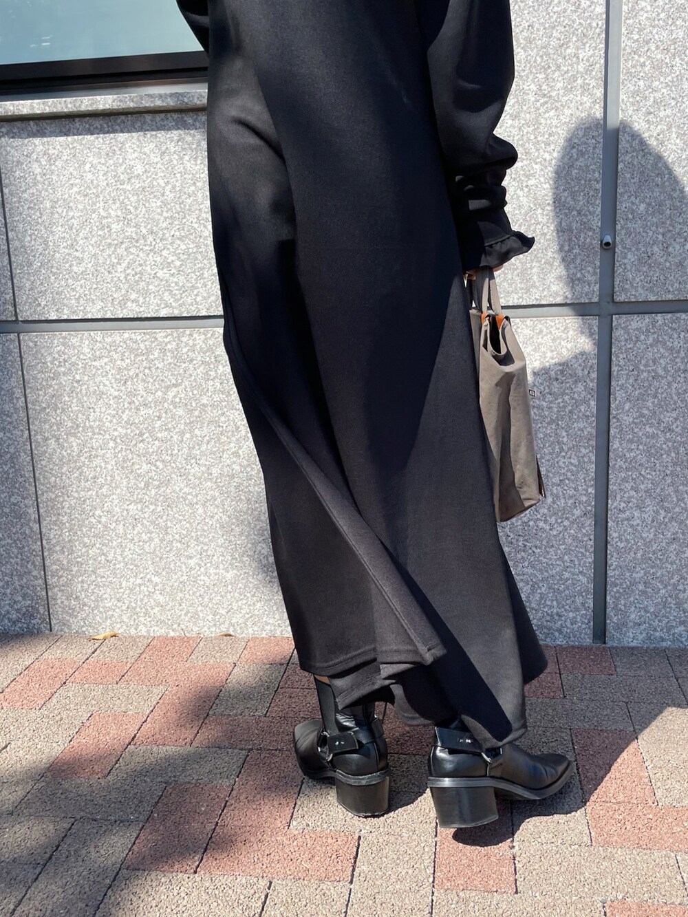 ブラック系のワンピース、ベージュ系のカーディガン/ボレロ、ブラウン系のバッグを着用したレディースの秋コーディネートの5枚目の写真