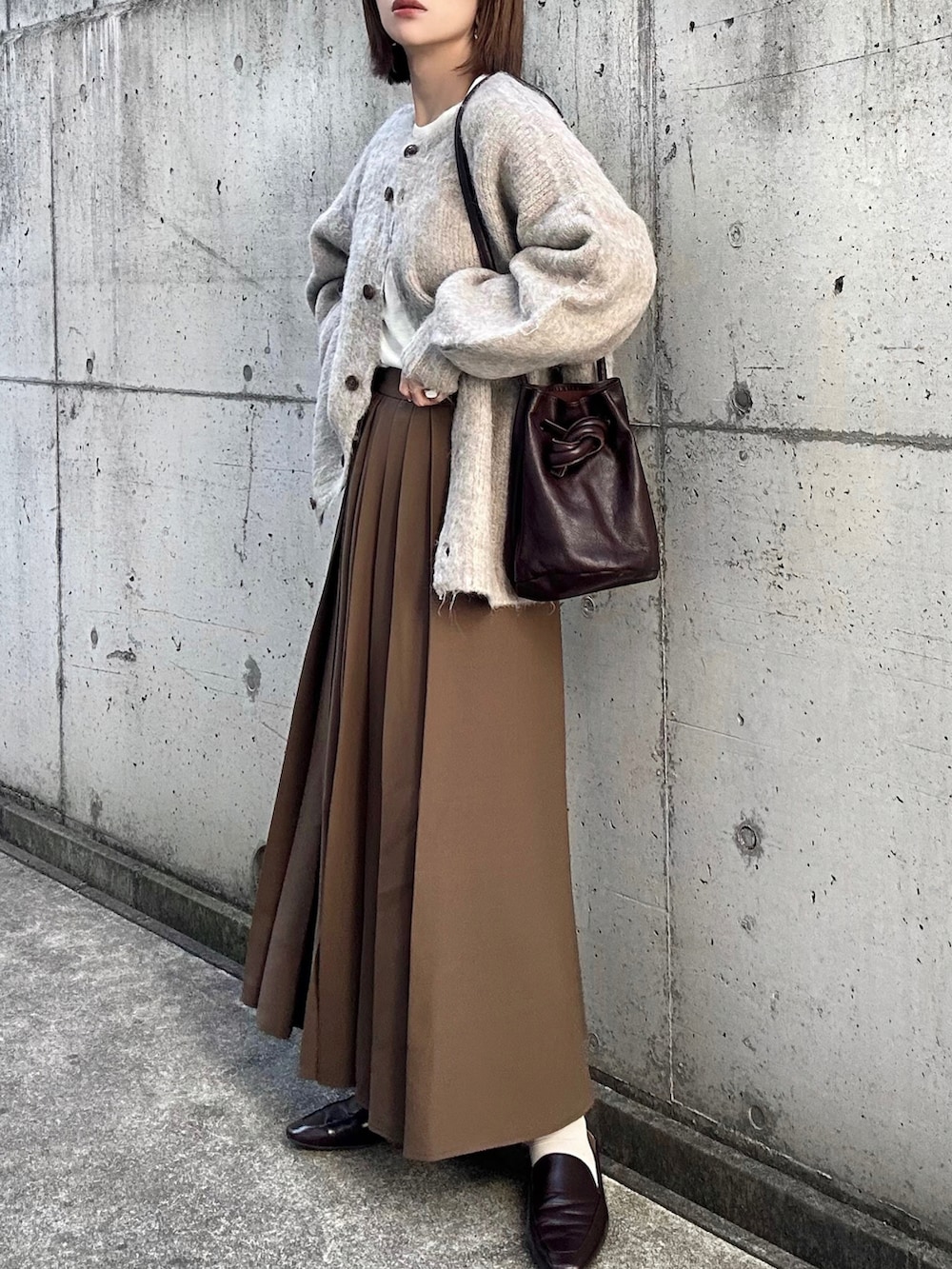 ベージュ系のカーディガン/ボレロ、ホワイト系のTシャツ/カットソー、ブラウン系のスカートを着用したレディースの秋コーディネートの2枚目の写真