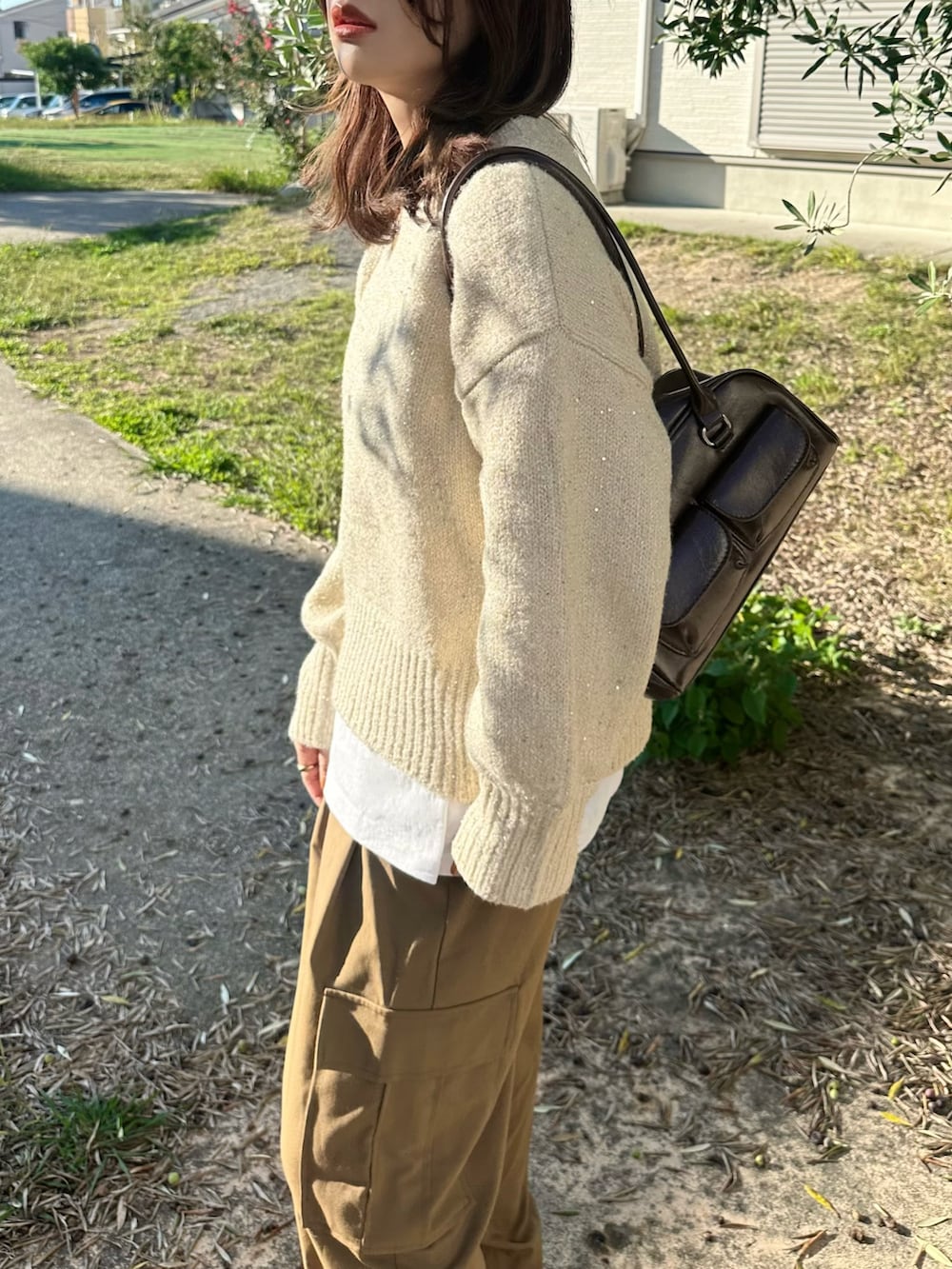 ベージュ系のニット/セーター、ブラウン系のパンツ、ブラウン系のショルダーバッグを着用したレディースの秋コーディネートの5枚目の写真